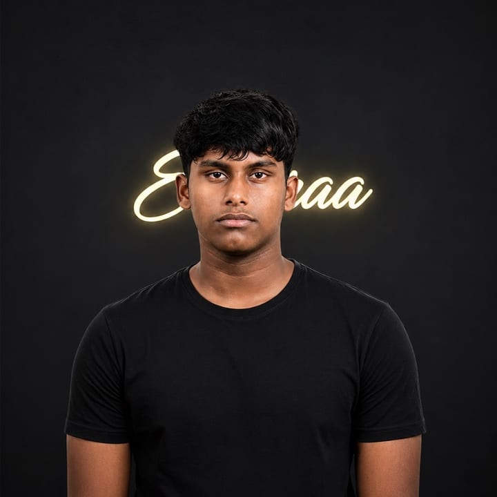 Muhammed Ajlan in a black T-shirt standing in front of a dark wall, with a warm glowing neon script sign behind him